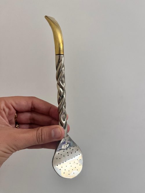 Un bombillon pico de loro en alpaca et bronze qui sert à à filtrer l'herbe à maté et boire l'infusion