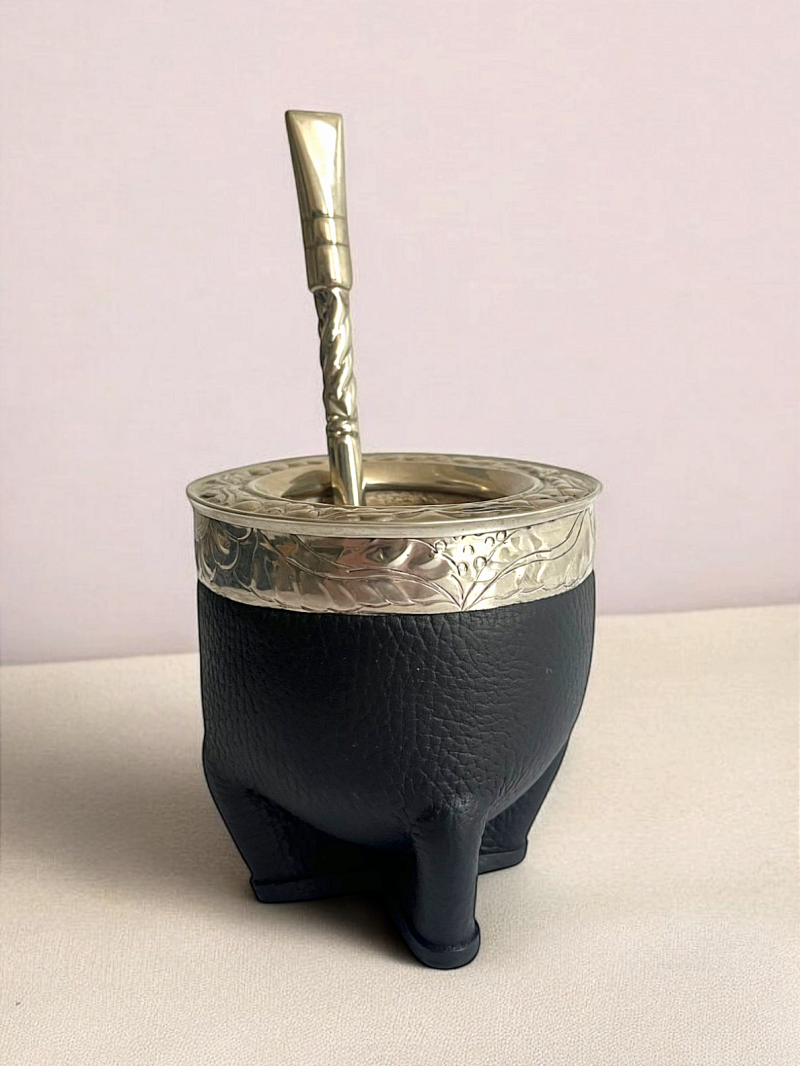 Calabaza de mate hecha a mano. Calabaza brasileña extragruesa recubierta de doble cuero negro. Está reforzada por una virola de alpaca grabada a mano.