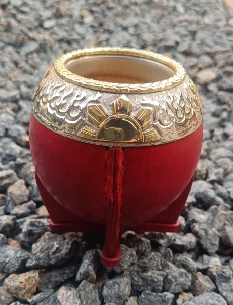 A personalised mate calabash handmade by a craftsman. It is covered in red leather and reinforced with an Alpaca virola.
