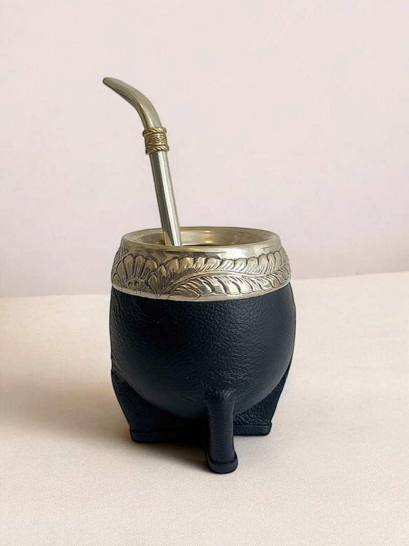 Handmade torpedo maté calabash. Handmade in Argentina. Covered in double black leather, it is reinforced by a hand-engraved alpaca Virola.