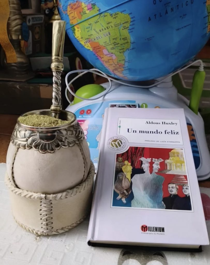 Calebasse à maté criollo artisanale avec livre et carte du monde en arrière-plan